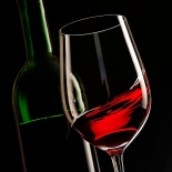 Geschwenkter Wein im Glas mit Flasche